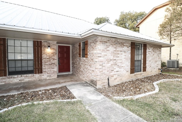 7227 Trace Buckle, San Antonio, TX 78240 - doorway to property with metal roof, central air condition unit, and brick siding