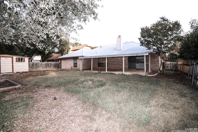 rear view of house featuring a lawn, a patio area, and an outdoor structure