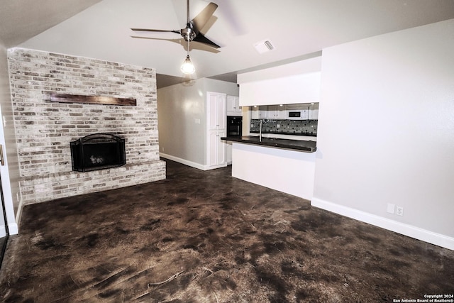 7227 Trace Buckle, San Antonio, TX 78240 - unfurnished living room with finished concrete flooring, a brick fireplace, baseboards, vaulted ceiling, and ceiling fan