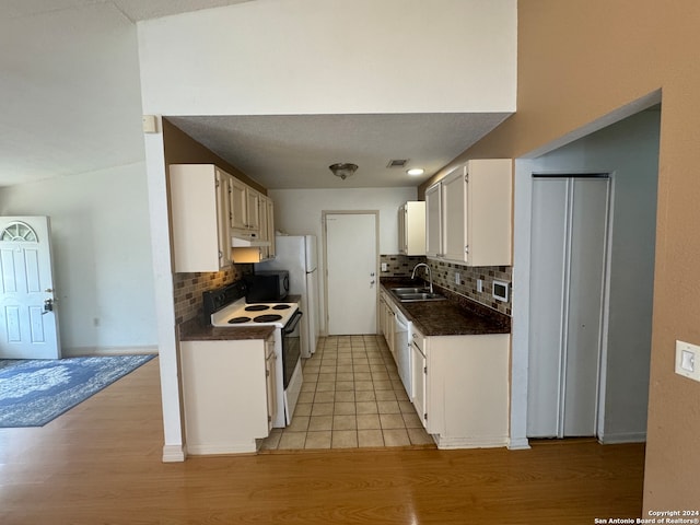 kitchen featuring white cabinets, sink, white electric range, and light wood-type flooring