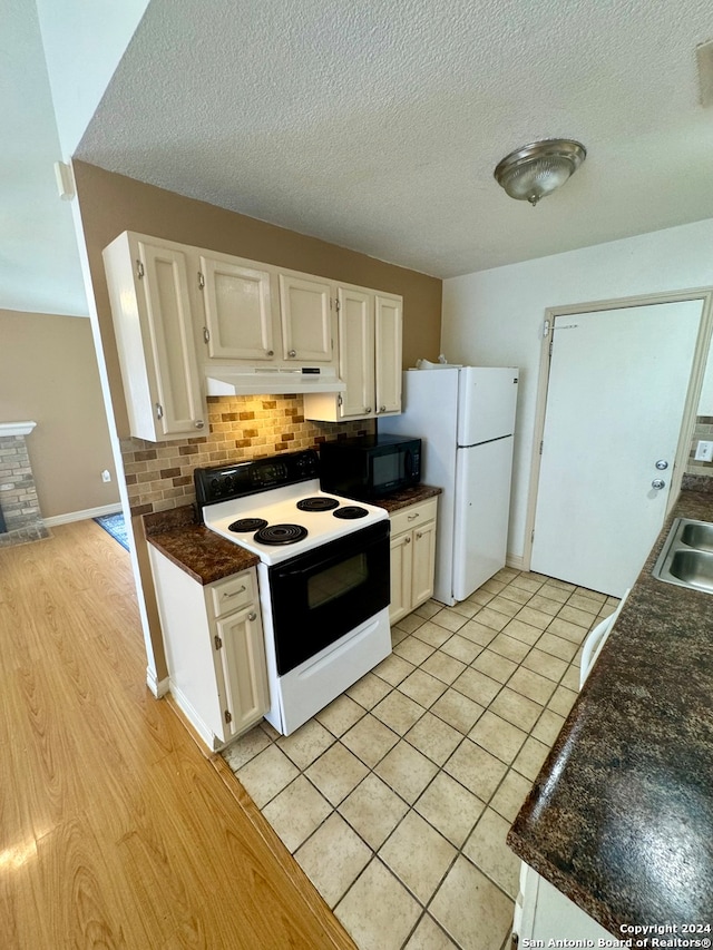 kitchen featuring white cabinetry, decorative backsplash, white appliances, a textured ceiling, and light wood-type flooring