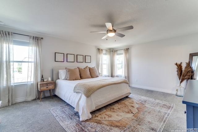 bedroom with ceiling fan, multiple windows, and carpet flooring