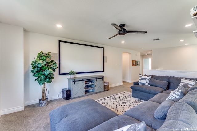 cinema with ceiling fan and light colored carpet