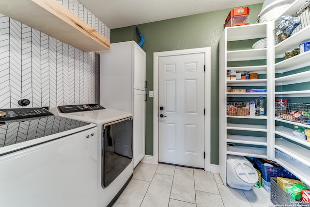 clothes washing area featuring a textured ceiling, light tile patterned floors, and independent washer and dryer