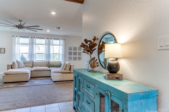 tiled living room with a textured ceiling and ceiling fan