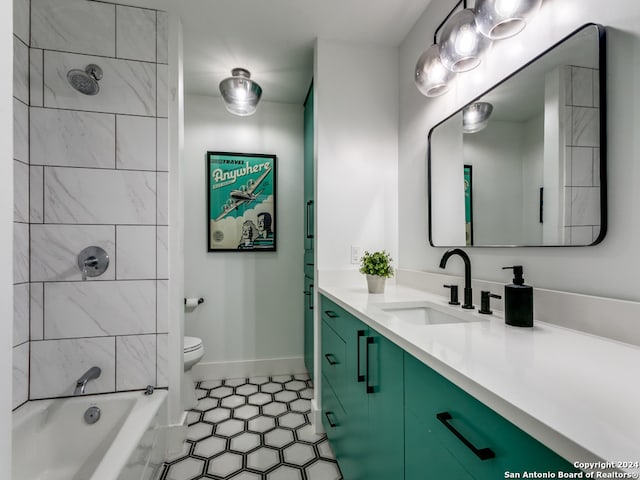 full bathroom featuring vanity, tile patterned flooring, tiled shower / bath, and toilet