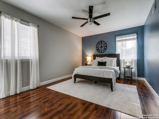 bedroom featuring multiple windows, ceiling fan, and dark hardwood / wood-style floors