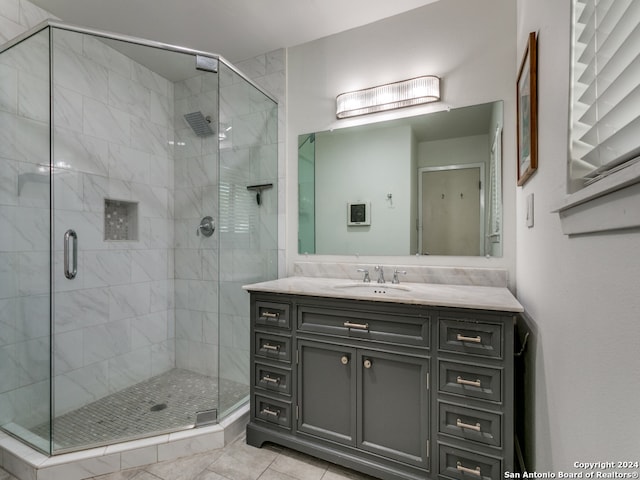 bathroom with tile patterned flooring, vanity, and a shower with door