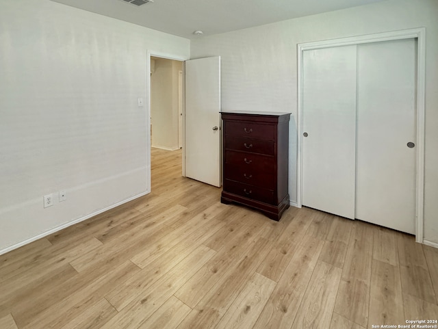 unfurnished bedroom featuring a closet and light wood-type flooring