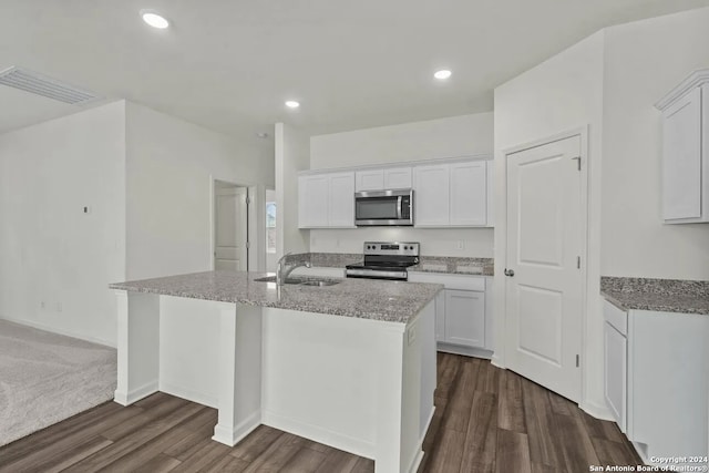 kitchen with white cabinetry, dark hardwood / wood-style flooring, an island with sink, and stainless steel appliances