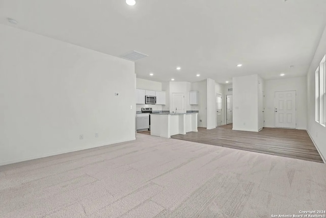 unfurnished living room featuring light carpet