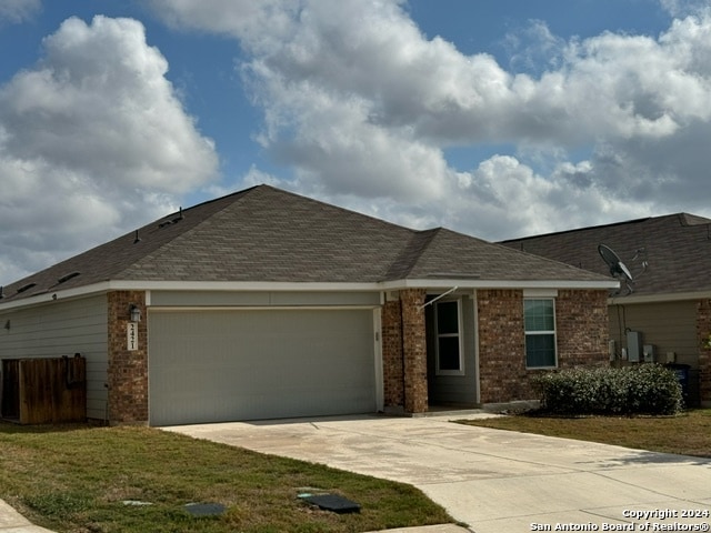 single story home featuring a front lawn and a garage