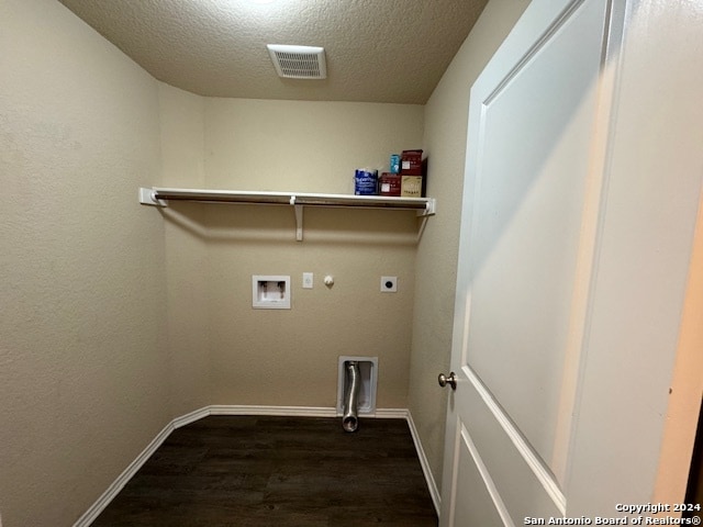 washroom with hookup for a gas dryer, hookup for a washing machine, dark hardwood / wood-style floors, a textured ceiling, and hookup for an electric dryer