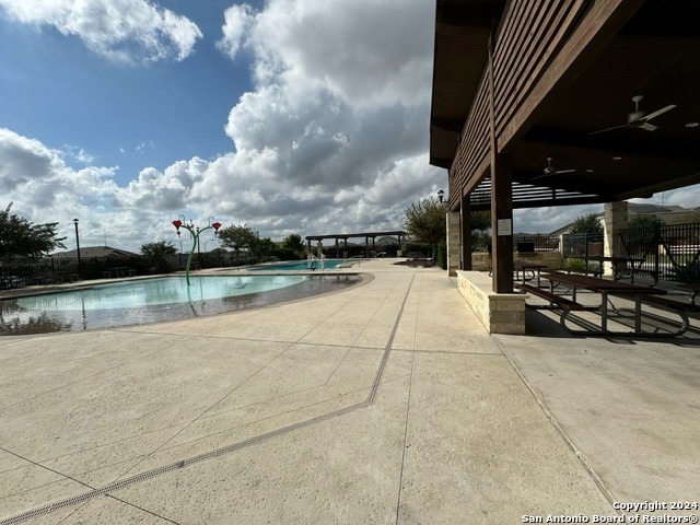 view of swimming pool featuring a patio and ceiling fan