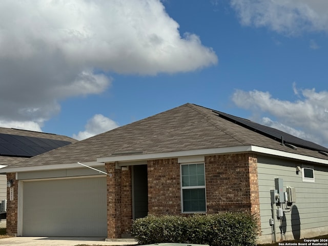 view of front facade featuring solar panels and a garage