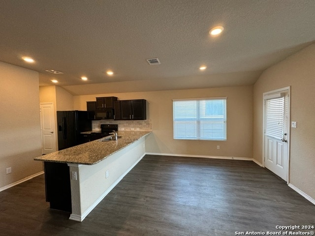 kitchen with black appliances, light stone counters, a textured ceiling, dark hardwood / wood-style flooring, and kitchen peninsula