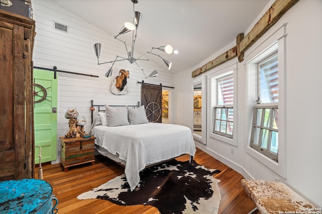 1517 S Magnolia St, Rockport, TX 78382 - bedroom featuring a barn door, vaulted ceiling, wooden walls, and wood finished floors
