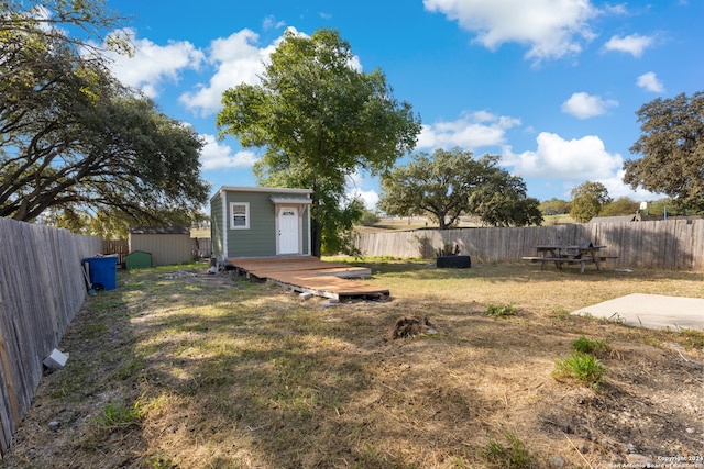 view of yard featuring a storage shed and a wooden deck