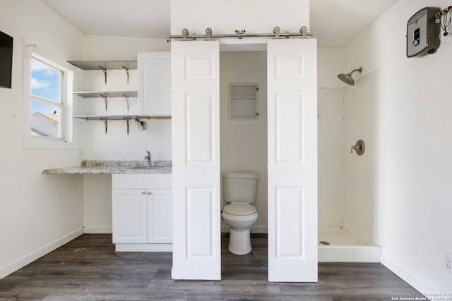 bathroom featuring a shower, wood-type flooring, vanity, and toilet