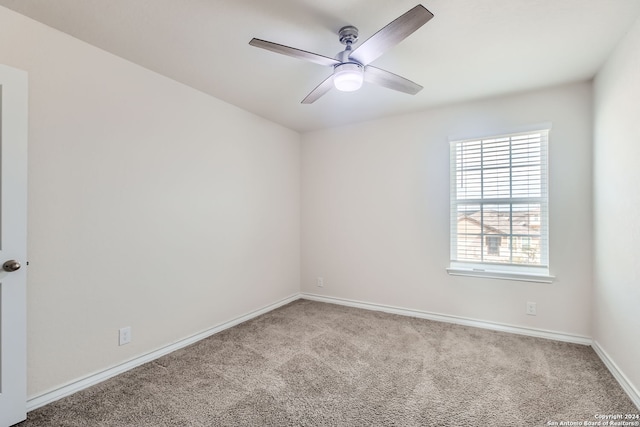 carpeted spare room featuring ceiling fan