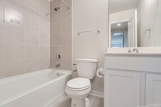 full bathroom featuring toilet, tile patterned floors, vanity, and tiled shower / bath combo