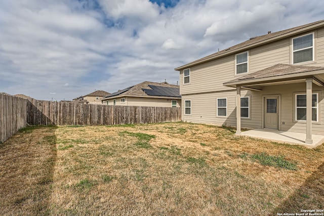 rear view of property with a lawn and a patio area