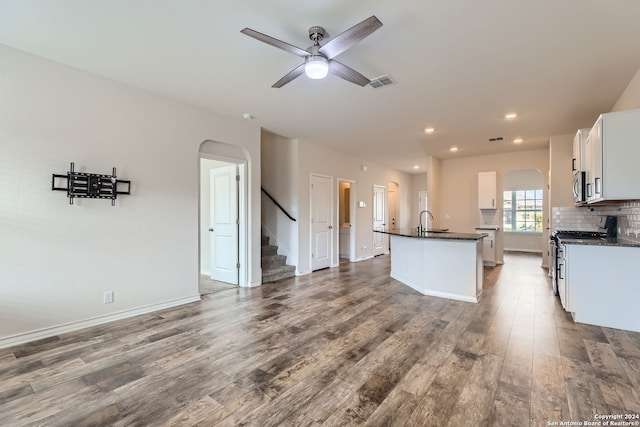 kitchen featuring stainless steel appliances, a kitchen island with sink, sink, wood-type flooring, and white cabinets