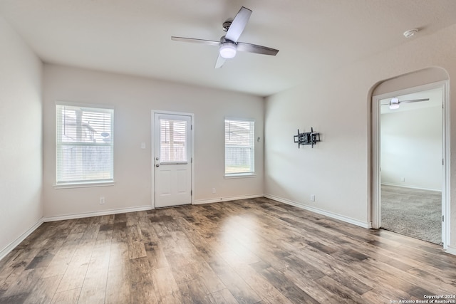 empty room featuring ceiling fan, hardwood / wood-style flooring, and a healthy amount of sunlight