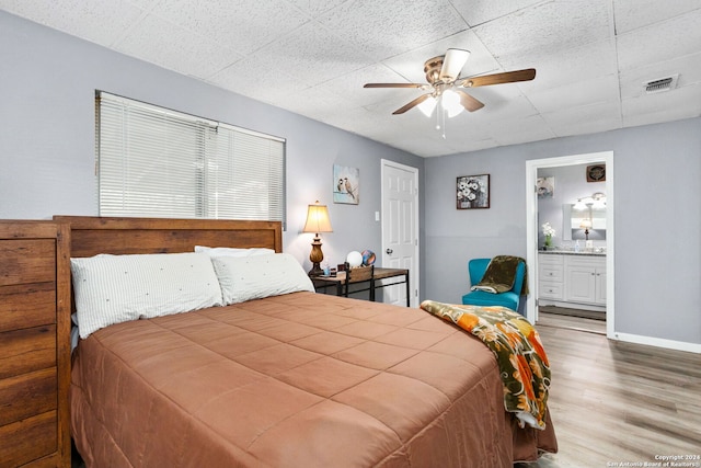 bedroom with hardwood / wood-style floors, ensuite bath, and ceiling fan