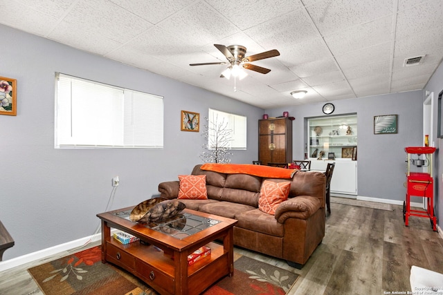 living room with wood-type flooring, a drop ceiling, washer / clothes dryer, and ceiling fan