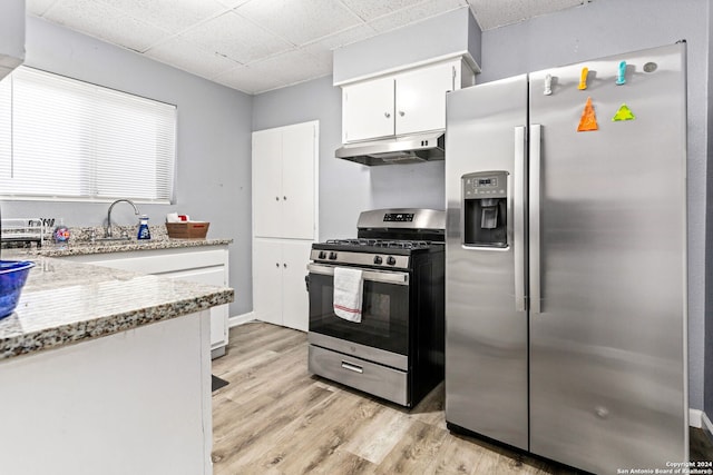 kitchen with appliances with stainless steel finishes, light stone counters, sink, light hardwood / wood-style flooring, and white cabinets