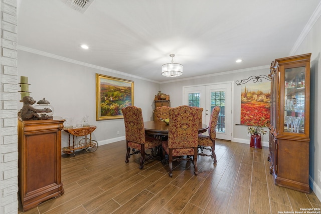 dining space featuring wood-type flooring, french doors, crown molding, and a notable chandelier