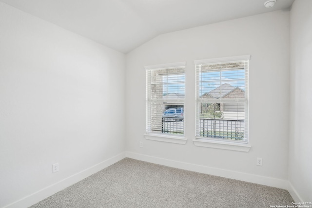 unfurnished room with lofted ceiling, carpet flooring, and baseboards