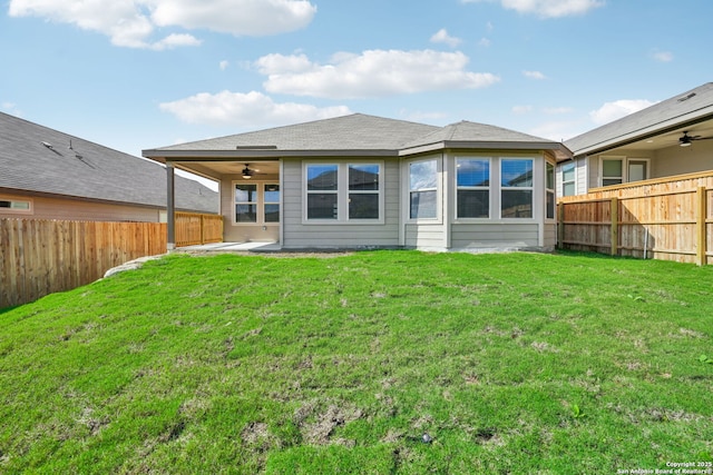 rear view of house featuring a ceiling fan, a fenced backyard, and a yard