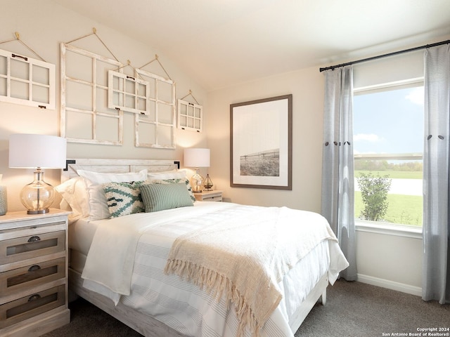 carpeted bedroom with lofted ceiling and baseboards