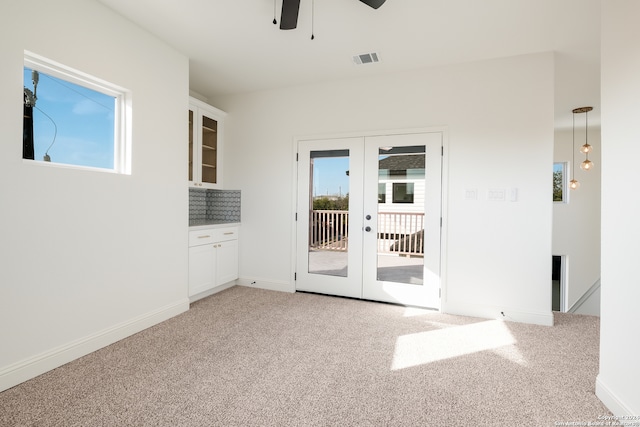 spare room featuring ceiling fan, french doors, and carpet