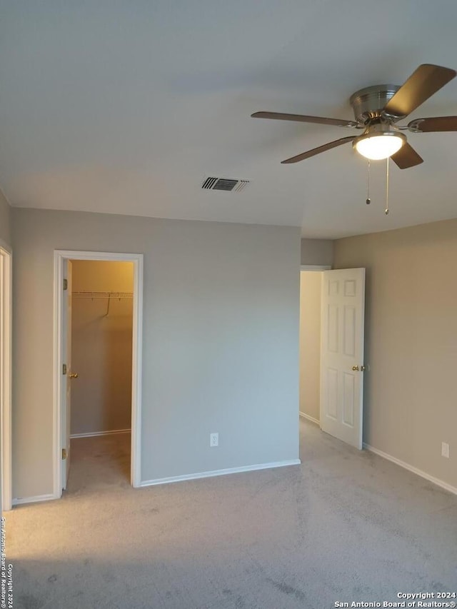 spare room featuring light carpet and ceiling fan