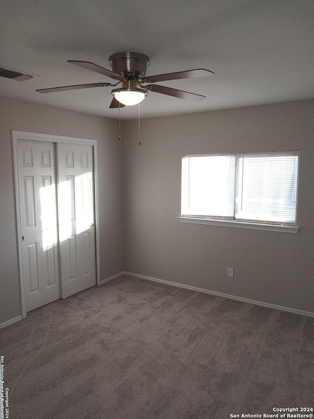 unfurnished room featuring ceiling fan and carpet