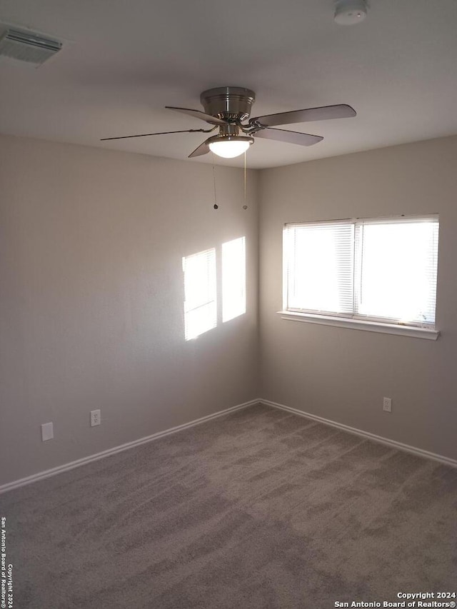 spare room featuring ceiling fan and carpet