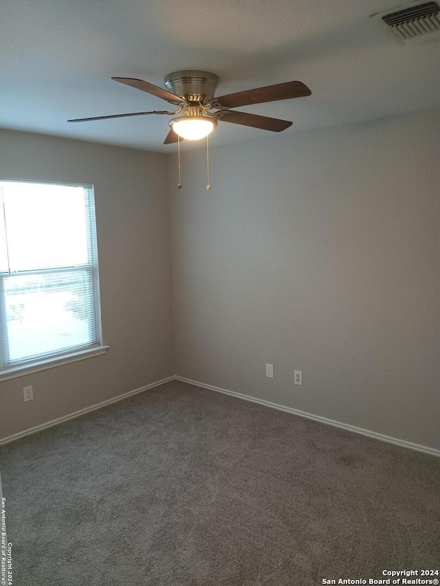 empty room featuring ceiling fan and carpet