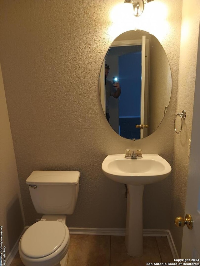 bathroom with toilet and tile patterned floors