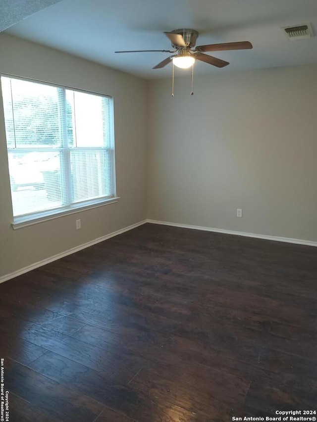 unfurnished room with ceiling fan and dark wood-type flooring