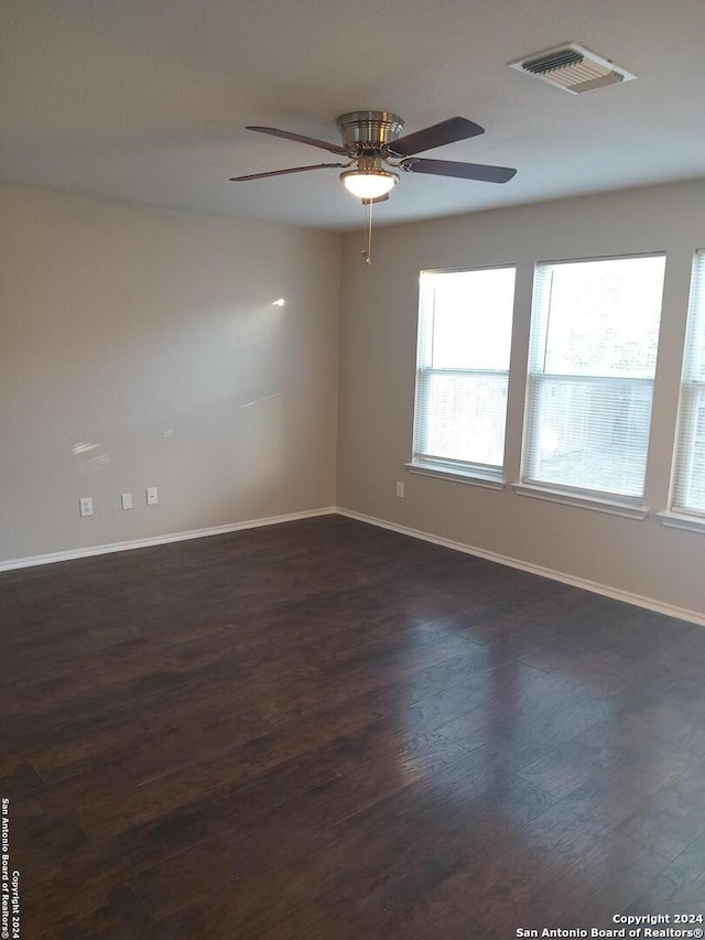 spare room with ceiling fan and dark hardwood / wood-style flooring