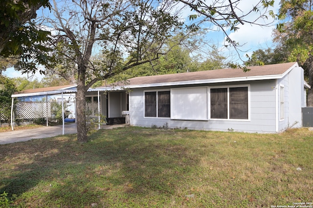 view of front facade featuring a front lawn and a carport