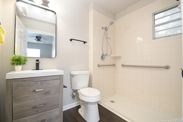 bathroom featuring tiled shower, hardwood / wood-style floors, vanity, and toilet