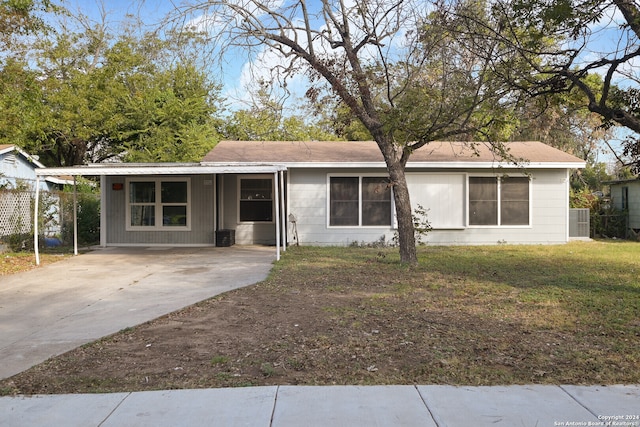 ranch-style home featuring a front lawn and a carport