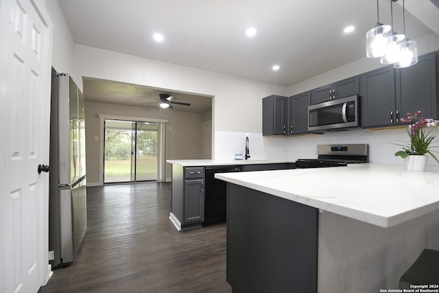 kitchen featuring light stone countertops, dark hardwood / wood-style flooring, gray cabinetry, stainless steel appliances, and hanging light fixtures