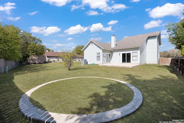 rear view of property featuring a lawn, a patio, and cooling unit