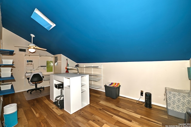 unfurnished office featuring dark hardwood / wood-style flooring, lofted ceiling with skylight, and ceiling fan