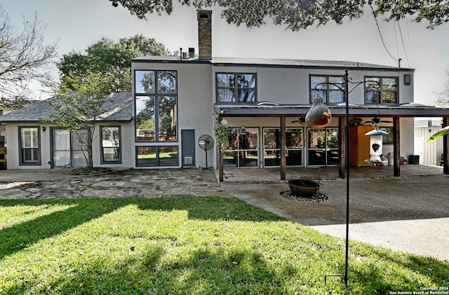 rear view of house featuring a lawn, a patio area, and a fire pit